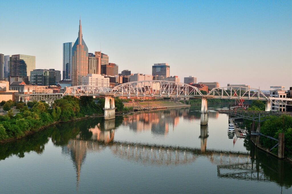 Nashville, Tennessee skyline at sunset with the Cumberland River and Shelby Street Bridge